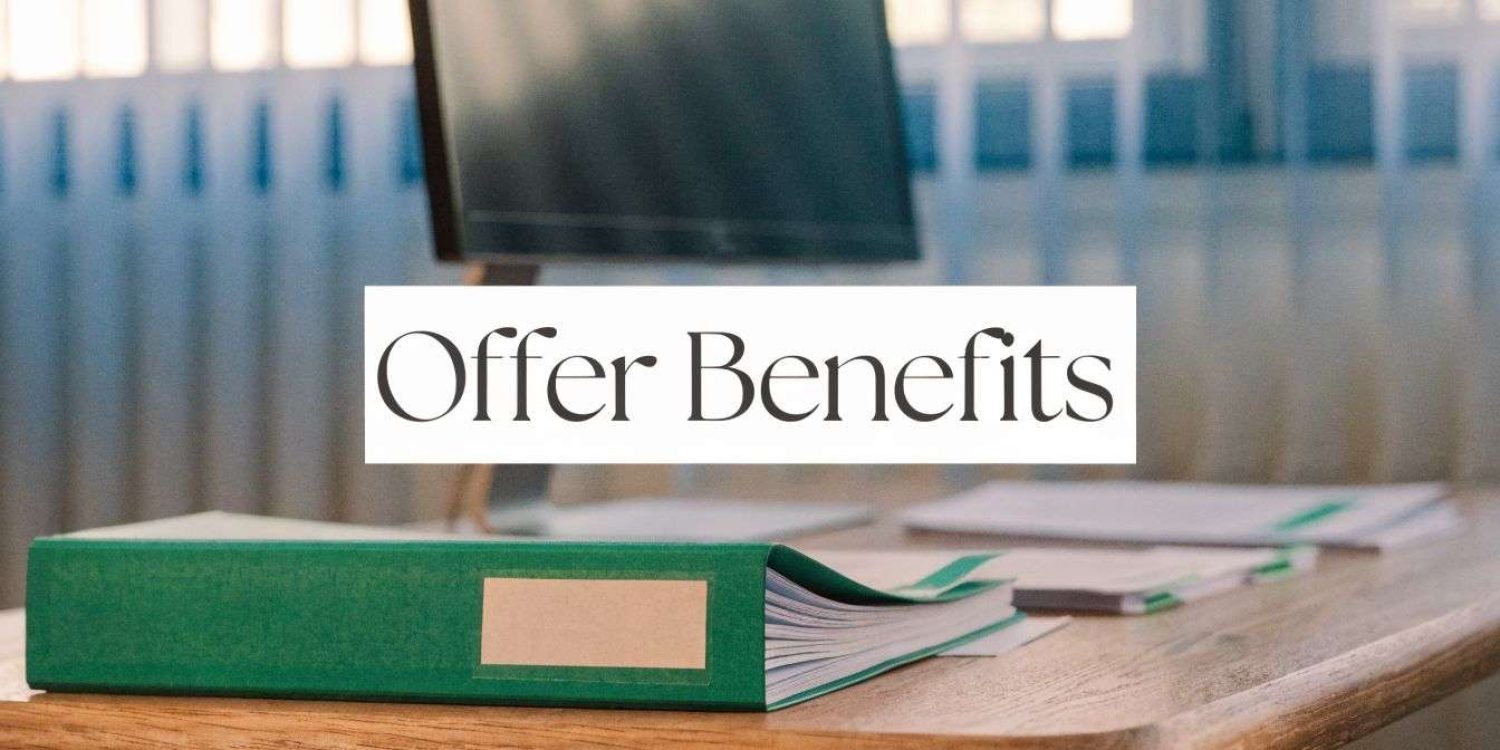 Desk on a wooden table with a green binder and papers, overlaid by the words 'Offer Benefits' in a white banner.
